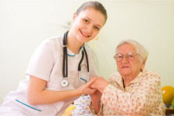 a nurse holding old woman's hand